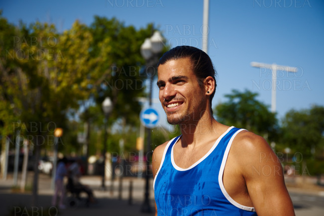 Happy young sportsman smiling cheerfully outdoors