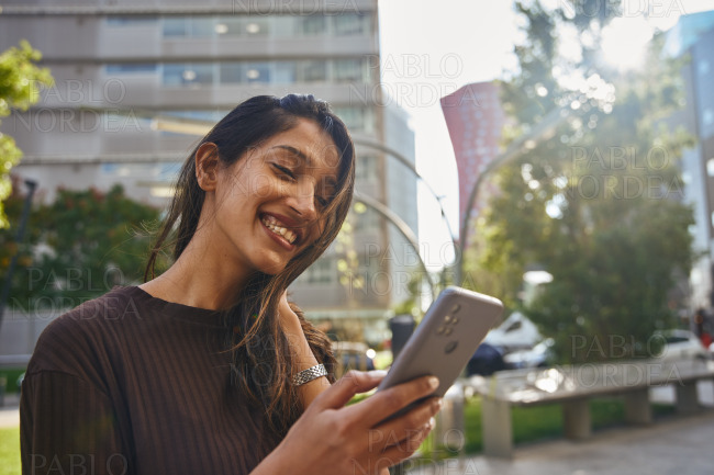 Portrait of young happy businesswoman with phone