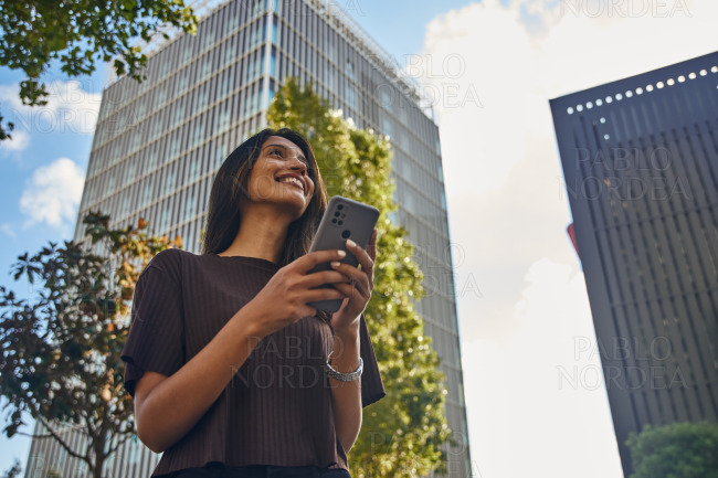 Smiling businesswoman standing with mobile phone