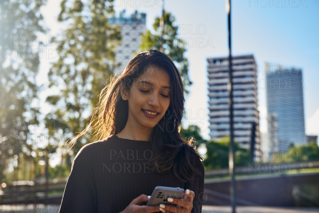 Smiling businesswoman working on mobile phone