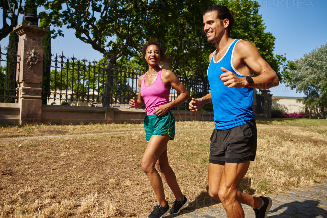 Smiling young couple jogging together outdoors