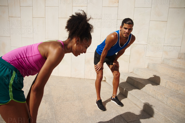 Sporty ethnic couple taking a break from jogging