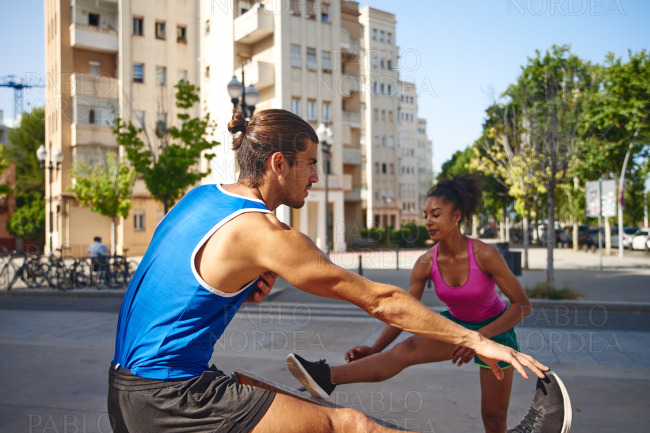 Sporty young couple doing stretch exercises stock photo
