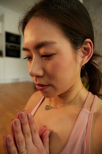 Woman in praying pose practicing yoga in the room
