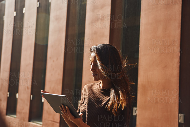 Young attractive businesswoman using tablet in sun