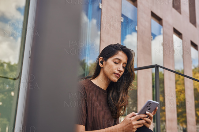Young beautiful businesswoman sitting with phone