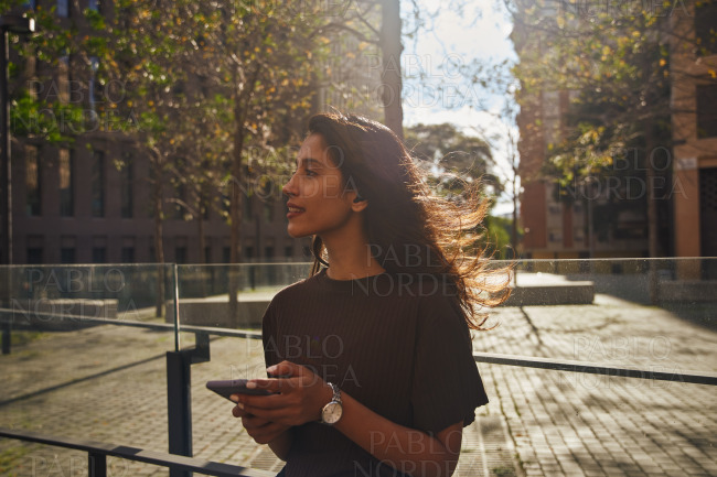 Young businesswoman on street holding mobile phone