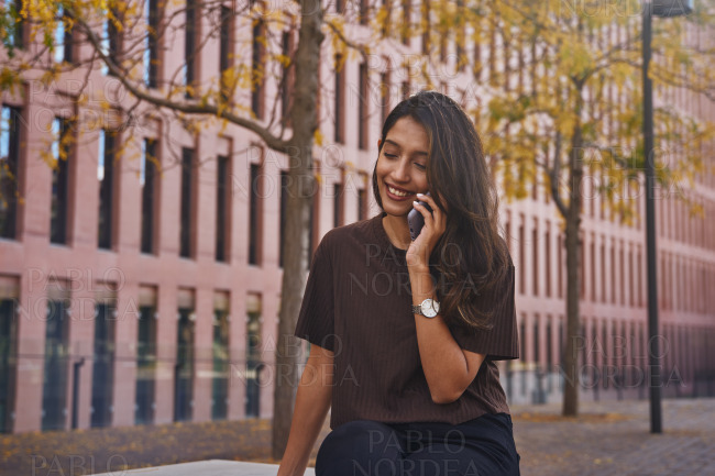 Young businesswoman sitting and using phone