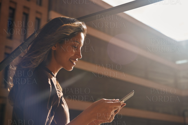 Young businesswoman standing and using tablet