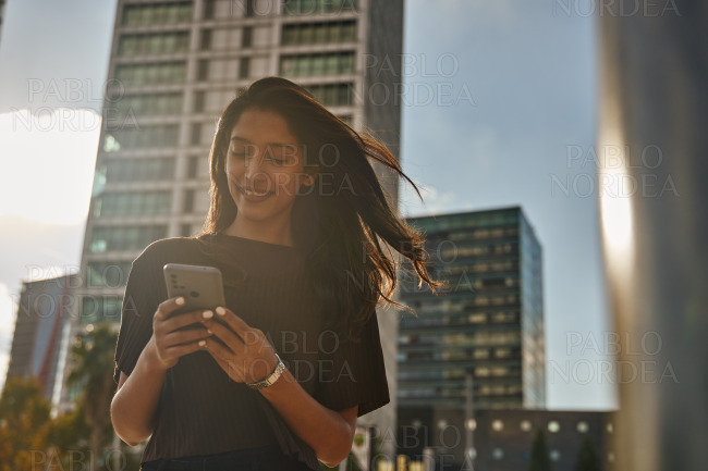 Young businesswoman text messaging on street