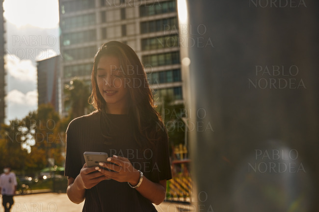 Young businesswoman using mobile phone on street