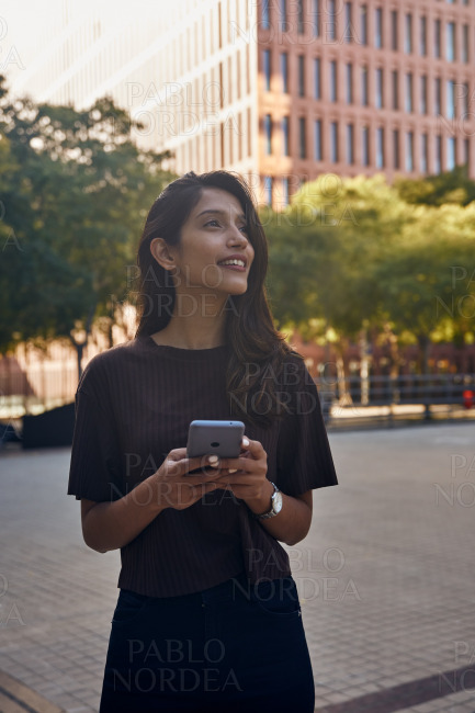 Young businesswoman with mobile phone on street