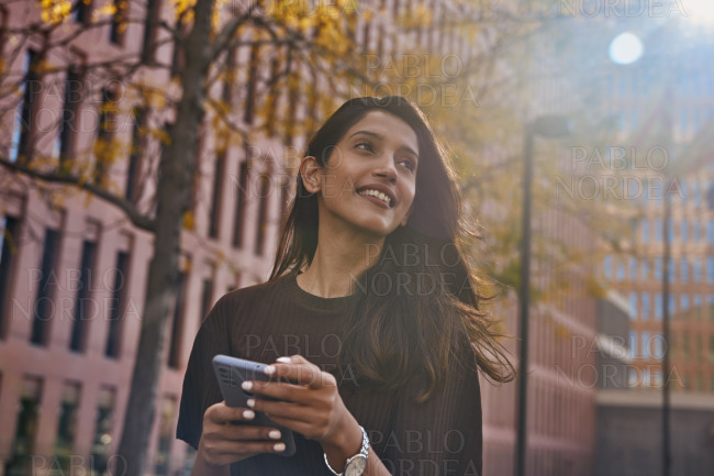 Young cheerful businesswoman with mobile phone