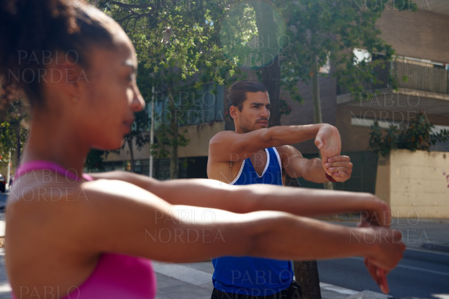Young couple doing stretch exercises outdoors