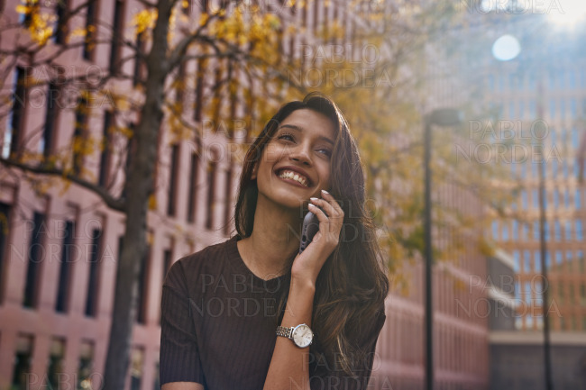 Young happy businesswoman talking on mobile phone