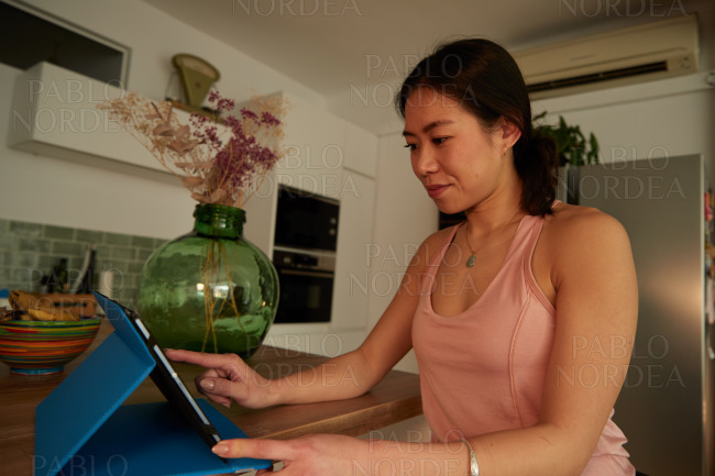 Young woman smiling while using tablet