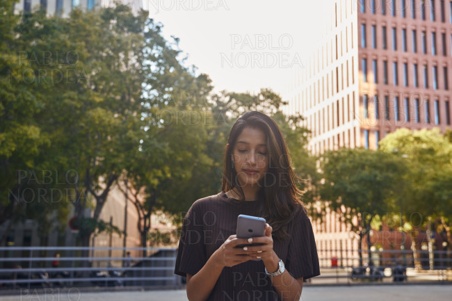 Young woman standing and using phone