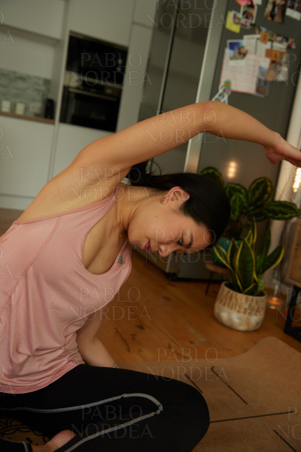 Young woman stretching while practicing yoga