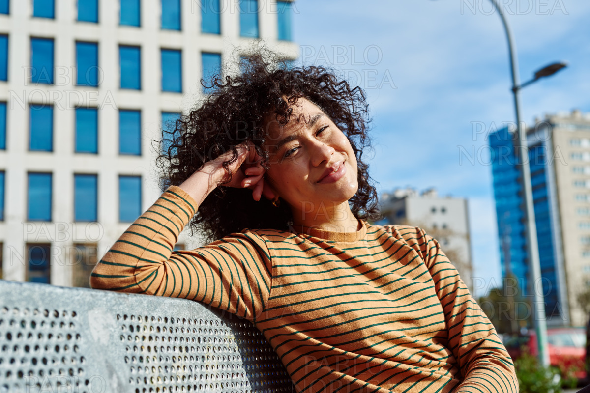 Happy young woman smiling at camera outdoors stock photo