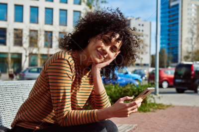 Cute young woman with smartphone looking at you
