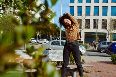 Fit young woman stretching her body in the city