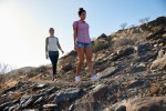 Two healthy girls walking on hillside