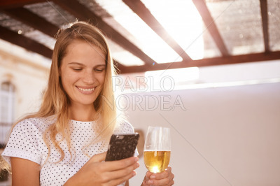 Beautifull blond with beer and cellphone