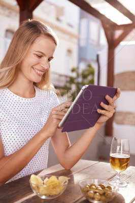 Blond girl typing on her tablet