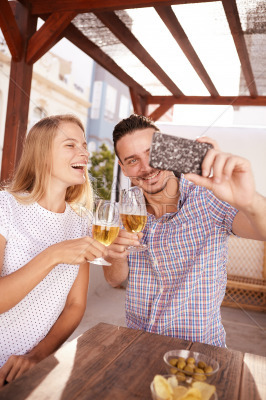 Couple taking selfie clinking their glasses