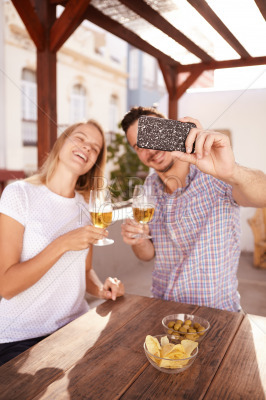 Couple taking selfie with their drinks