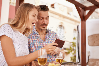 Cute couple looking at cellphone surprised