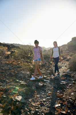 Cute girls walking down rocky path