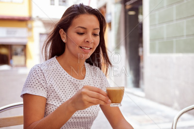 Girl drinking coffee in a street cafe
