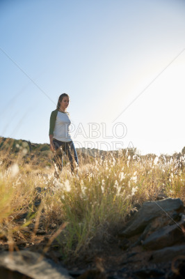 Girl standing on hill in sunlight