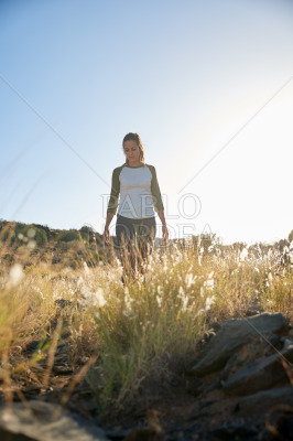 Girl walking on hill in sunshine