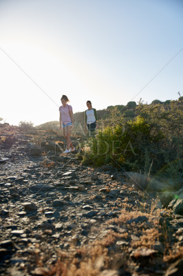 Girls hiking down rocky mountain side