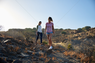 Girls strolling down rocky mountain path