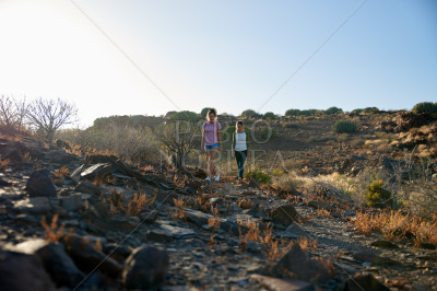 Girls walking down rocky mountain path