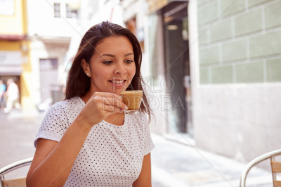 Happily smiling young girl drinking coffee