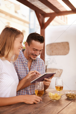 Happy millennial couple sharing a touchpad