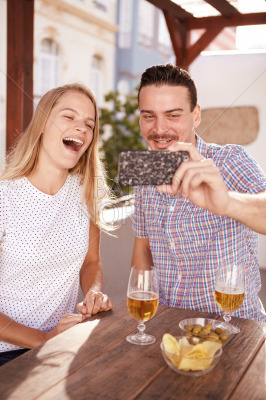 Laughing couple taking a happy selfie
