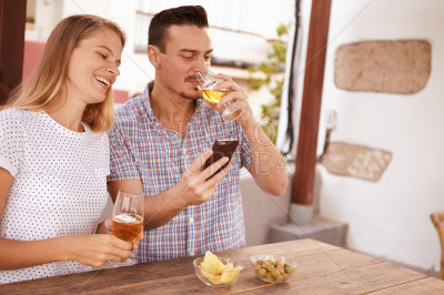 Man sipping beer while sharing cellphone