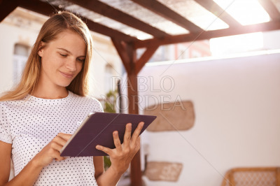 Pretty blond girl holding a touchpad