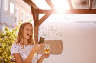 Pretty blond girl with beer and cellphone