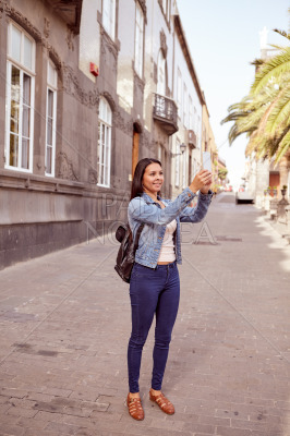 Pretty young girl taking a picture with cell phone