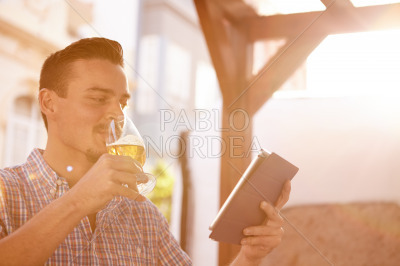 Short haired man with beer and touchpad