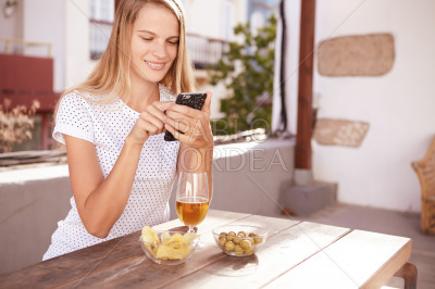 Smiling blond girl typing a message