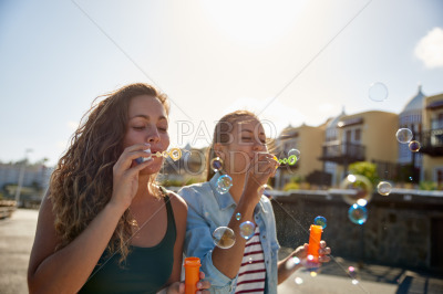 Two beautiful girls blowing some bubbles