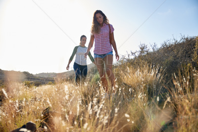 Two concentrating girls hiking on hill