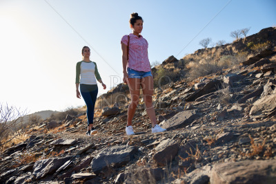 Two healthy girls walking on hillside